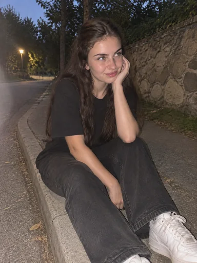 Sitting outdoors in a black T-shirt and jeans